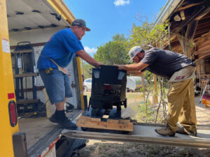 photo of two men moving 500 pounds of stove