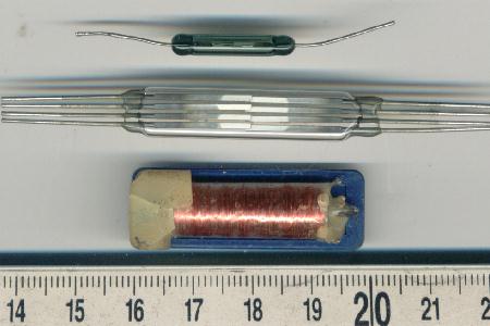 photo of a Single-pole reed switch, four-pole reed switch and single-pole reed relay. Scale in centimeters.