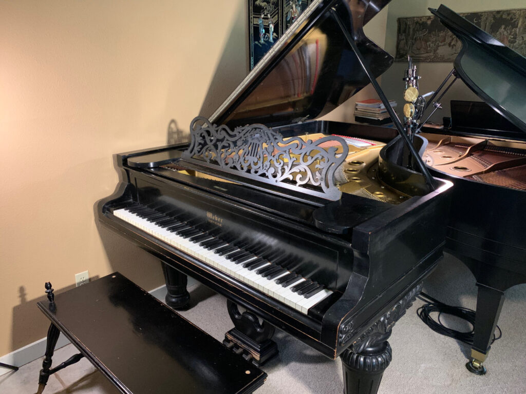 Featured image for “I Didn’t See It Coming”: a restored 1893 Weber grand piano in its music room at Roy Creek Ranch.